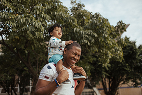 child sitting on man's shoulders